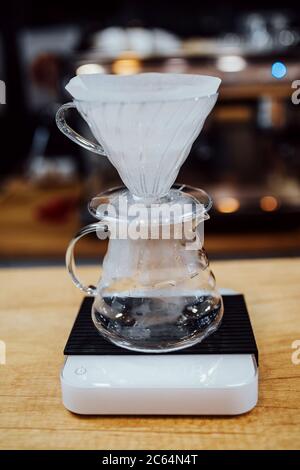 Purover with a paper filter on the scales - a professional barista - a drip way to brew Stock Photo