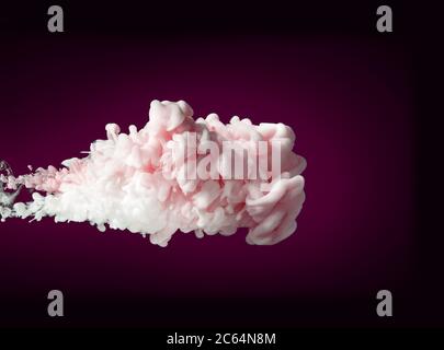 cloud of white and pink ink swirling in water Stock Photo