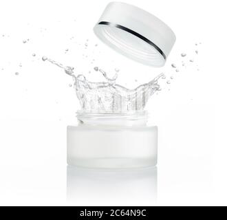 moisturizing liquid splashing out of a small jar isolated on white background Stock Photo