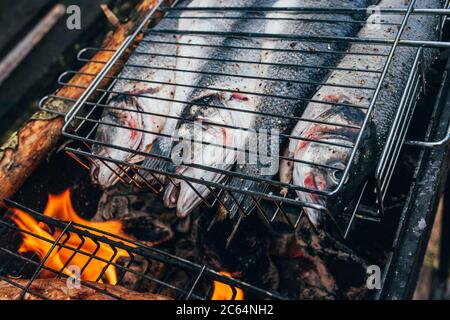 tightly lying seabass fish on the grill - fish feast - vegetarian diet food Stock Photo