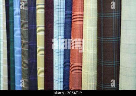 Vertically hanging samples of multi-colored fabric close-up Stock Photo
