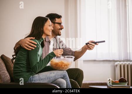 Couple is relaxing at home. They are watching tv. Stock Photo