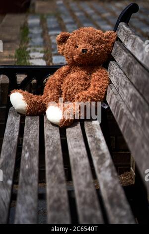 A abandoned or lost teddy bear left on a bench in old Isleworth, London ...