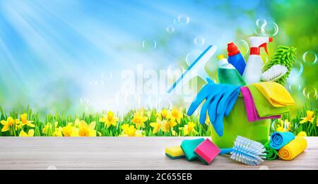 Bucket with cleaning items on blurry spring background with sun beams and soapbubbles Stock Photo