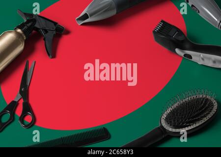 Bangladesh flag with hair cutting tools. Combs, scissors and hairdressing tools in a beauty salon desktop on a national wooden background. Stock Photo