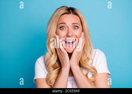 Portrait of astonished positive crazy woman hear incredible lottery win information impressed touch face hands wear good look outfit isolated over Stock Photo