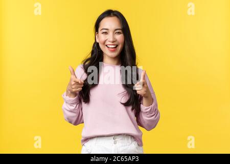 People emotions, lifestyle and fashion concept. Enthusiastic and friendly smiling pretty girl pointing fingers at camera, praising nice job, picking Stock Photo