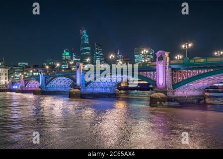 Night scenic view of the Thames river with Southwark bridge and financial district in the background.  Cityscape of London, United Kingdom Stock Photo