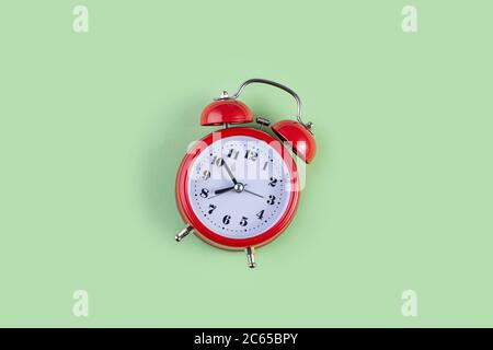 Red vintage alarm clock on light green color background. Alarm clock with place for text. Time management concept, business planning Stock Photo