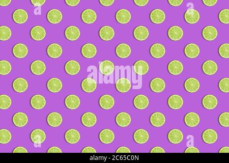 Colorful fruit seamless pattern of fresh lime slices on a purple background. Trendy sunlight Summer pattern. Minimal summer concept. flat lay food tex Stock Photo
