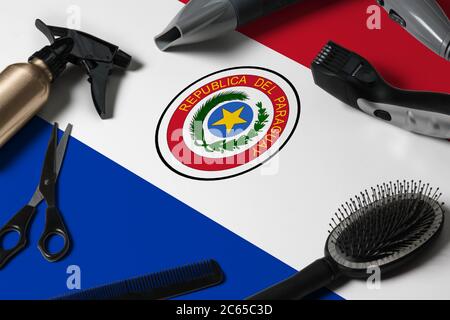Paraguay flag with hair cutting tools. Combs, scissors and hairdressing tools in a beauty salon desktop on a national wooden background. Stock Photo