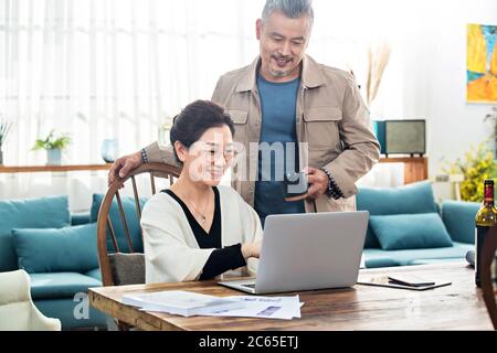 Happy old couple using laptop at home Stock Photo