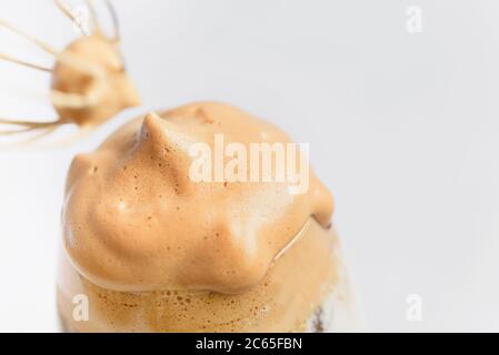 Iced Dalgona Coffee trendy fluffy creamy whipped latte espresso with foam in transparent glass on marble background. Trendy drink city lock down and s Stock Photo