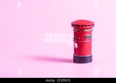 Red postbox on a pink background, British style Stock Photo