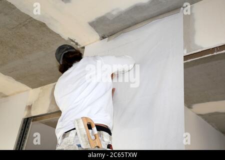 Handwerker (Maler) bei Tapezierarbeiten Stock Photo