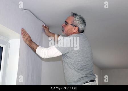 Handwerker (Maler) bei Tapezierarbeiten (Model released) Stock Photo