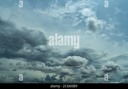 Blue sky and dark cumulus clouds. Cloudscape. Blue sky and fluffy clouds. The storm sky before raining. Rain clouds. Beauty in nature. Nature Stock Photo