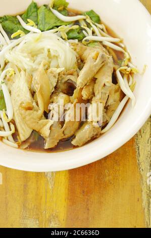 boiled thin rice noodles chicken leg and feet with bean sprout in herb brown soup on bowl Stock Photo