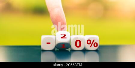 Hand turns dice and changes the expression "-10%" to "-20%". Stock Photo