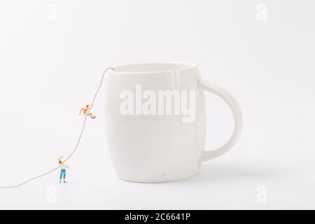 Man climbing cup on white background Stock Photo
