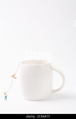 Man climbing cup on white background Stock Photo