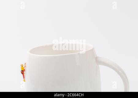 Man climbing cup on white background Stock Photo