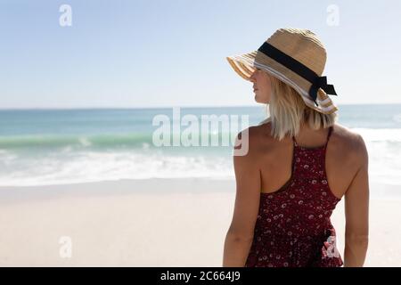 Woman wearing hat standing on the beach Stock Photo