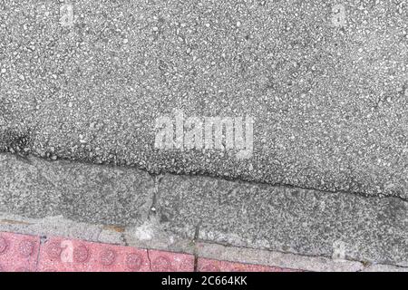 Gray asphalt and red road tiles. Early types of road surface. Copyspace. Close-up Stock Photo