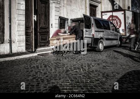 Dead man pushed into hearse in coffin, Rome, Italy Stock Photo