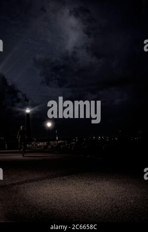 Way on a dam in Den Helder with lighthouse at night, Holland, Netherlands Stock Photo