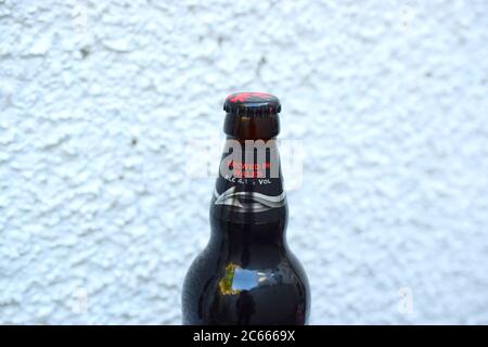 Dark beer bottle from Brains brewery on light textured background. Stock Photo