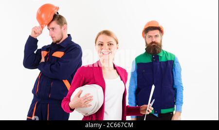 Team of two workmen and woman standing grouped, wearing hard hats smiling at camera isolated on white Stock Photo
