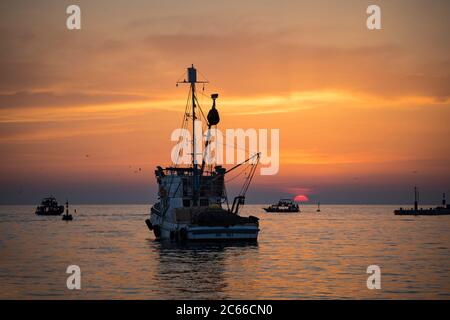 Fishing boat at sunset in the harbour of Rovinj, Adriatic coast, Istria, Croatia Stock Photo
