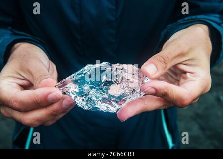 Hands holding an piece of ice broken off from a glacier, glacier lagoon in jokulsarlon, jökulsarlon Iceland, Scandinavia, Europe Stock Photo