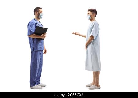 Full length profile shot of a medical worker in a blue uniform with a face mask and a patient talking isolated on white background Stock Photo
