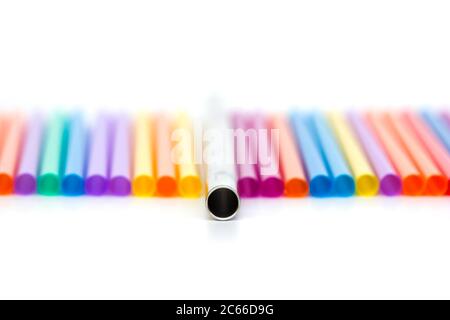 Zero waste concept. plastic vs eco steel straw. one reusable sustainable cocktail metal straw and multiplicity multi-colored plastic straws on white b Stock Photo