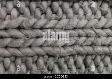 Detail of a rustic handmade chunky rug. Knitted wool background. Stock Photo