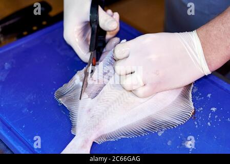Filleting a plaice step-by-step, cutting off the fins Stock Photo