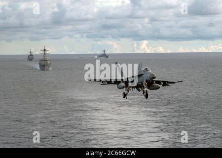 A U.S. Navy F/A-18E Super Hornet fighter aircraft, from the Dambusters of Strike Fighter Squadron 195 approaches to land on the flight deck of the Nimitz-class aircraft carrier USS Ronald Reagan during dual-carrier operations July 6, 2020 in the South China Sea. Stock Photo