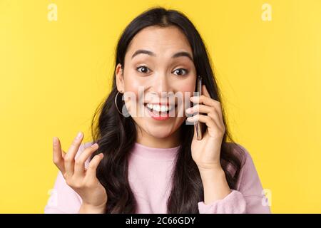 People emotions, lifestyle leisure and beauty concept. Glad asian girl receive wonderful news over phone, talking on mobile and smiling amazed, raise Stock Photo