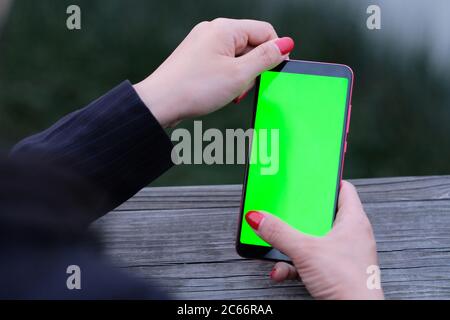 business woman using green screen smartphone. Blur background Stock Photo