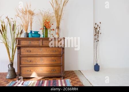 old antique old mahogany chest of drawers in a room with additional decor Stock Photo