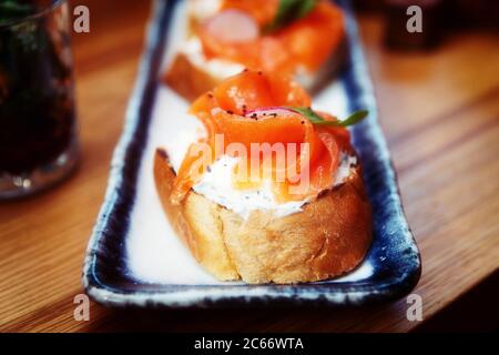 Smoked salmon slices and creamy cheese on bread, set of bruschettas, toned Stock Photo