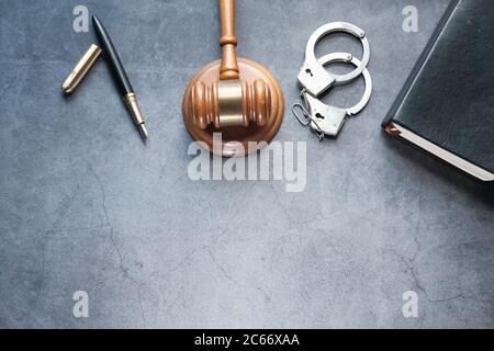 gavel, book and handcuff on black background top down  Stock Photo