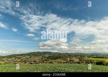Fast moving clouds in the sky captured during a sunny day overlooking the village and the high hills and mountains in the background foreground from a Stock Photo