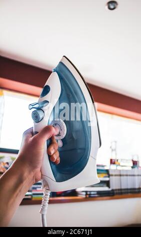 female hand holding air iron Stock Photo
