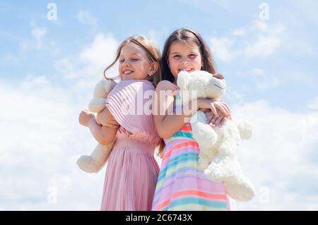 we are one. family bonding time. best friends hold bear toy. two sisters with teddy bear. happy childhood. summer vacation. small girls embrace. love and support. concept of sisterhood and friendship. Stock Photo