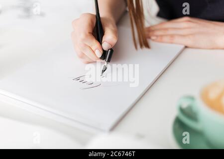 Close up photo of woman hands holding pen and writing beautiful notes on paper isolated Stock Photo