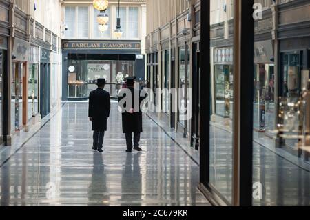 Glasgow, Scotland, UK. 7th July, 2020. Two of the concierges walking together along the Argyll Arcade shopping centre. Shops are allowed to re-open for business with the further easing of the coronavirus lockdown rules. Credit: Skully/Alamy Live News Stock Photo
