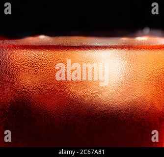Whiskey in frosted glass with natural ice. Macro shot of cold alcoholic drink. Black background. Stock Photo